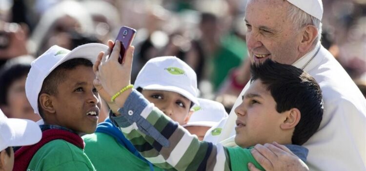 Foto di papa Francesco con fanciulli e smartphone